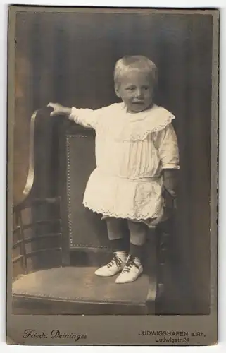 Fotografie Friedr. Deininger, Ludwigshafen a. Rh., Portrait hübsch gekleidetes Mädchen auf Stuhl stehend