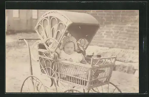 Foto-AK Baby sitzt im Korbkinderwagen