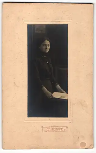 Fotografie Ed. Dickopf, Siegburg, Portrait elegant gekleidete Dame mit Zeitung an Tisch gelehnt
