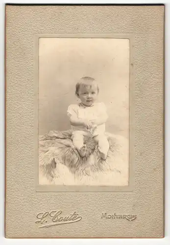 Fotografie L. Coute, Montargis, Portrait sitzendes Kleinkind im weissen Hemd mit kurzen Haaren