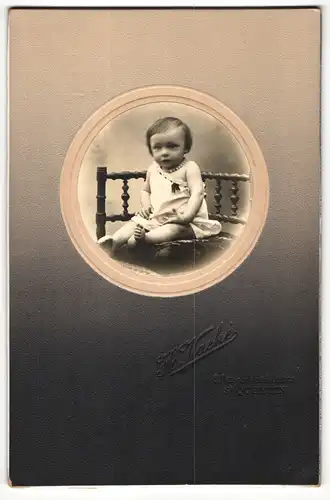 Fotografie H. Vache, St-Quentin, Portrait niedliches Kleinkind im Hemdchen auf Kissen sitzend