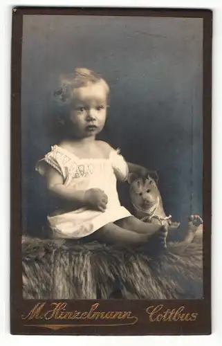 Fotografie M. Hinzelmann, Cottbus, Portrait sitzendes Kleinkind im weissen Hend mit Stofftier