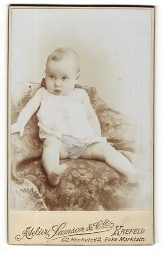 Fotografie Samson & Cie, Krefeld, Portrait bezauberndes Kleinkind im weissen Hemdchen