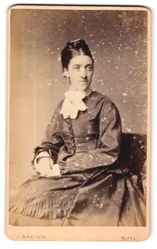 Fotografie J. Brown, Rhyl, Portrait dunkelhaarige schöne Frau mit Haar- und Ohrschmuck