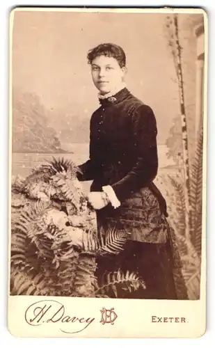 Fotografie H. Davey, Exeter, Dame im Kleid neben Farn
