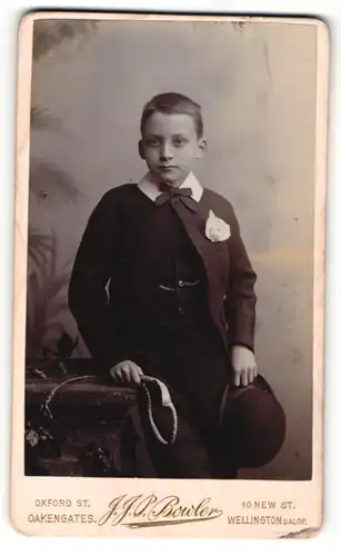Fotografie J. J. O. Bowler, Wellington, Junge im Anzug halb sitzend halb stehend mit Fliege