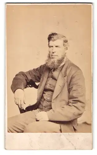 Fotografie J. Ballantine, Cumnock, Mann im Anzug sitzend mit krausem Vollbart