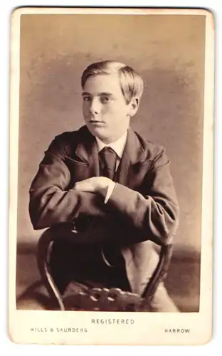 Fotografie Hills & Saunders, Harrow, Junger Mann im Anzug, sitztend