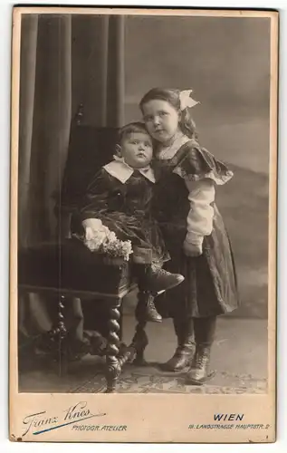 Fotografie Franz Knes, Wien, Portrait kleiner Junge und Mädchen in hübscher Kleidung mit Blumen