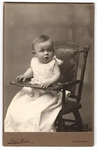 Fotografie Josef Henk, Oberhollabrunn, Portrait niedliches Kleinkind im weissen Kleid im Hochsitz