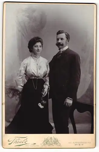 Fotografie Robert Thiele, Wien, Portrait bürgerliches Paar in hübscher Kleidung mit Blumen