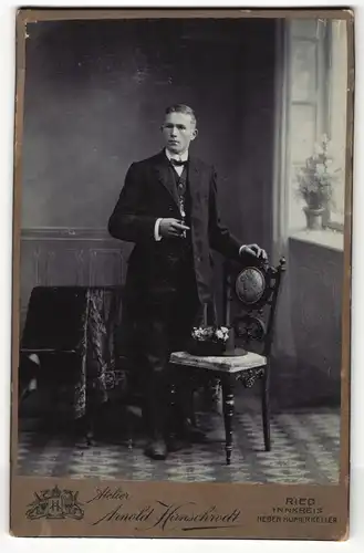 Fotografie Arnold Hirnschrodt, Ried, Portrait elegant gekleideter Herr mit Zigarre an Stuhl gelehnt