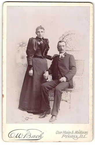 Fotografie C. W. Bach, Peoria, Ill., Portrait bürgerliches Paar in eleganter Kleidung mit Ansteckblumen