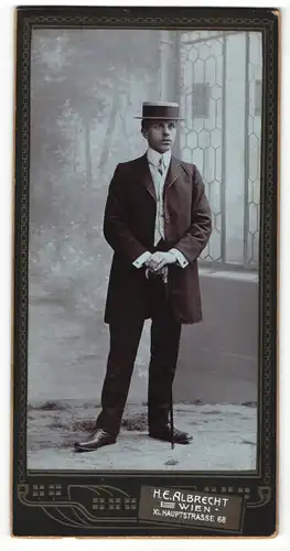 Fotografie H. E. Albrecht, Wien, Portrait junger Herr in eleganter Kleidung mit Hut und Stock