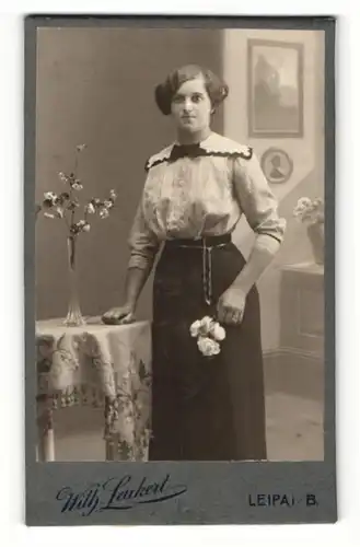 Fotografie Wilh. Leukert, Leipa i. B., Portrait hübsches Fräulein mit Blumen in der Hand