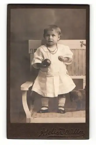 Fotografie Atelier Müller, Ort unbekannt, Portrait niedliches kleines Mädchen mit Ball in der Hand