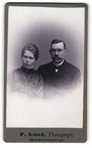 Fotografie P. Lund, Süderbrarup, Portrait elegant gekleidetes Paar