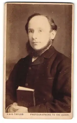 Fotografie A. & G. Taylor, Carlisle, Portrait bürgerlicher Herr im Anzug mit Bart und Buch