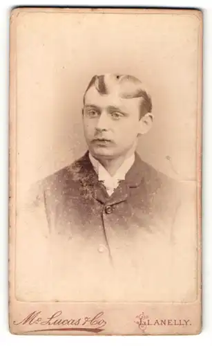 Fotografie M. Lucas & Co., Llanelly, Portrait junger Mann mit zeitgenöss. Frisur