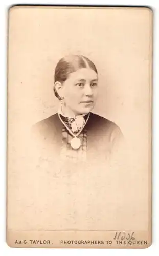 Fotografie A. & G. Taylor, Stockton-on-Tees, Portrait junge Dame in hübscher Kleidung mit Amulett