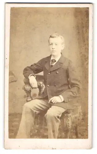 Fotografie Frederick Cole, London, Junge im Anzug sitzt auf einem Stuhl