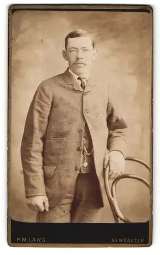 Fotografie P. M. Laws & Son, Newcastle, Mann mit Hand am Stuhl