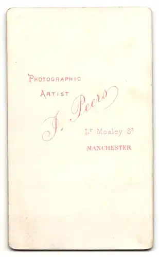 Fotografie J. Peers, Manchester, Frau mit Haarschmuck und brodiertem Kleid sitzt am Tisch