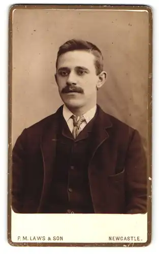 Fotografie P. M. Laws & Son, Newcastle, Portrait charmanter Herr im Anzug mit Krawatte und Schnurrbart