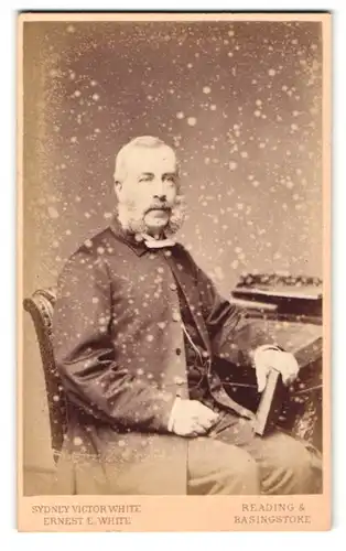 Fotografie Ernest E. White, Reading, Portrait bürgerlicher Herr mit Bart und Buch am Schreibtisch sitzend