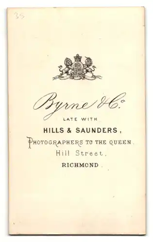 Fotografie Byrne & Co., Richmond, Portrait kleines Mädchen im weissen Kleid auf Sessel sitzend