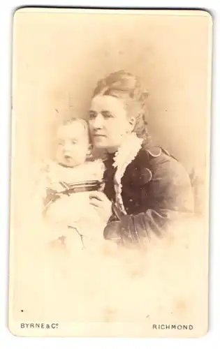 Fotografie Byrne & Co, Richmond, Portrait schöne junge Mutter mit blondem Mädchen im Arm