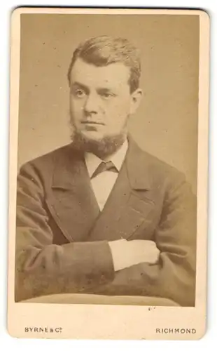 Fotografie Byrne & Co, Richmond, Portrait junger charmanter Mann mit Lincolnbart im Anzug