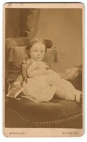 Fotografie Byrne & Co, Richmond, Portrait niedliches kleines Mädchen im Kleidchen mit karierten Schleifen