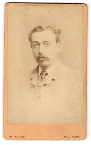 Fotografie Byrne & Co, Richmond, Portrait charmant blickender junger Mann in Krawatte und Jackett