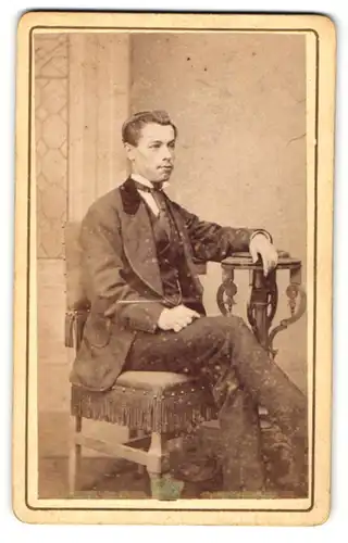 Fotografie Archer Clarke, Stourbridge, Portrait eleganter Herr mit Krawatte am Tisch sitzend