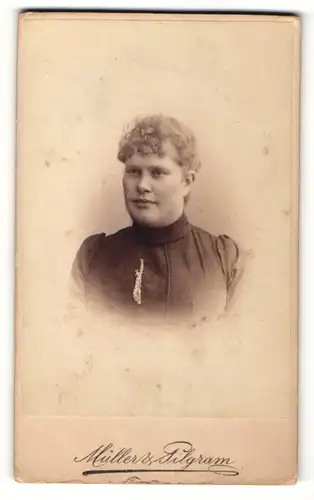 Fotografie Müller & Pilgram, Dresden, Portrait modsich frisierte Frau mit Schmuck am Kleid