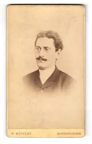 Fotografie W. Höffert, Dresden, Portrait charmanter Herr im Anzug mit Brille und Zwirbelbart