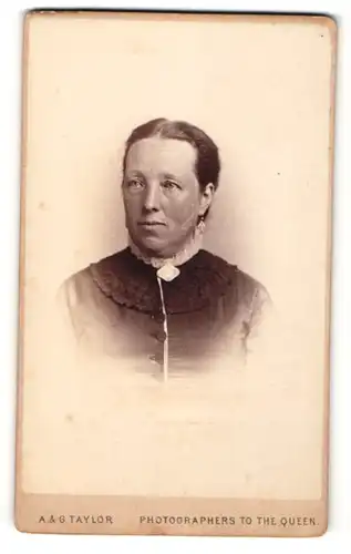 Fotografie A. & G. Taylor, London-W, Portrait bürgerliche Dame mit zurückgebundenem Haar und Kragenbrosche