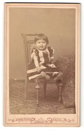 Fotografie Carl Hesse, Berlin, Portrait kleines Mädchen auf Sitzmöbel