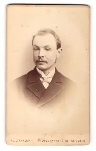 Fotografie A. & G. Taylor, London, Mann im Anzug mit Schnurrbart und zurückgekämmten Haaren