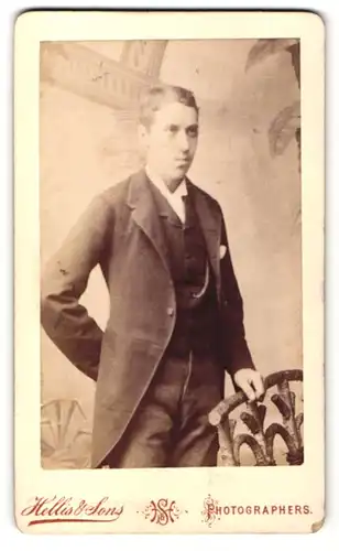 Fotografie Hellis & Sons, London, Portrait elegant gekleideter Herr an Geländer gelehnt