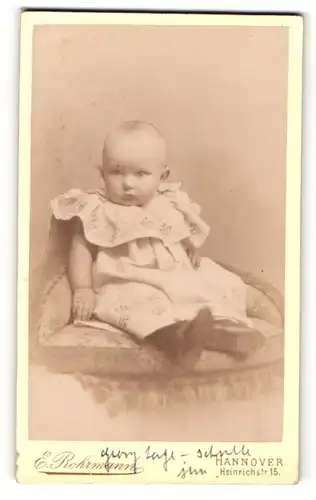 Fotografie E. Rohrmann, Hannover, Portrait sitzendes Kleinkind im hübschen Kleid mit Schühchen