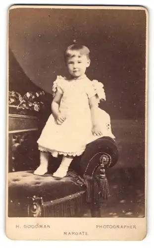 Fotografie H. Goodman, Margate, Portrait lächelndes kleines Mädchen im weissen Rüschenkleidchen
