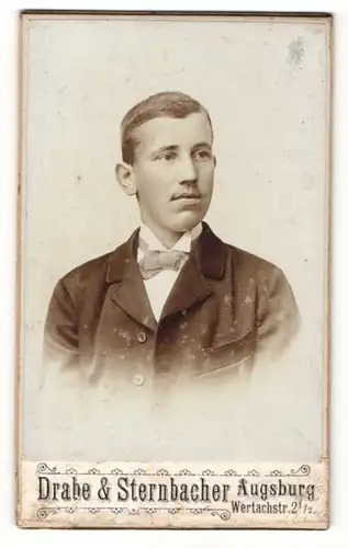 Fotografie Drabe & Sternbacher, Augsburg, Portrait junger charmanter Mann in Fliege und Jackett