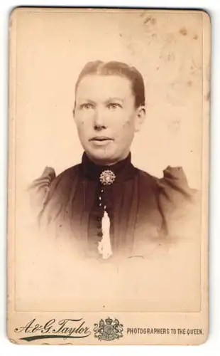 Fotografie A. & G. Taylor, Newcastle, Frau mit streng nach hinten gekämmten Haaren und Halsbrosche