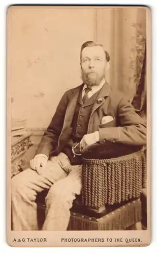 Fotografie A. & G. Taylor, Sunderland, Mann mit Seitenscheitel und Vollbart im Anzug sitzend