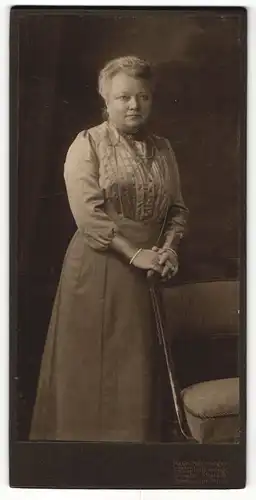 Fotografie E. Müller, Dresden, Dame mit Kette an Stuhl lehnend