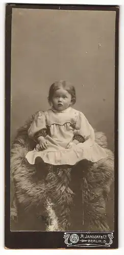 Fotografie A. Jandorf, Berlin, kleines Kind auf Fell sitzend