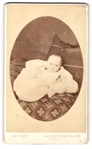 Fotografie Francis C. Earl, Worcester, Baby in weissem Kleid liegt gebettet auf Kissen