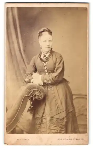 Fotografie W. V. Amey, Landport, Frau mit hochgebundenen Haaren lehnt auf Ottomane